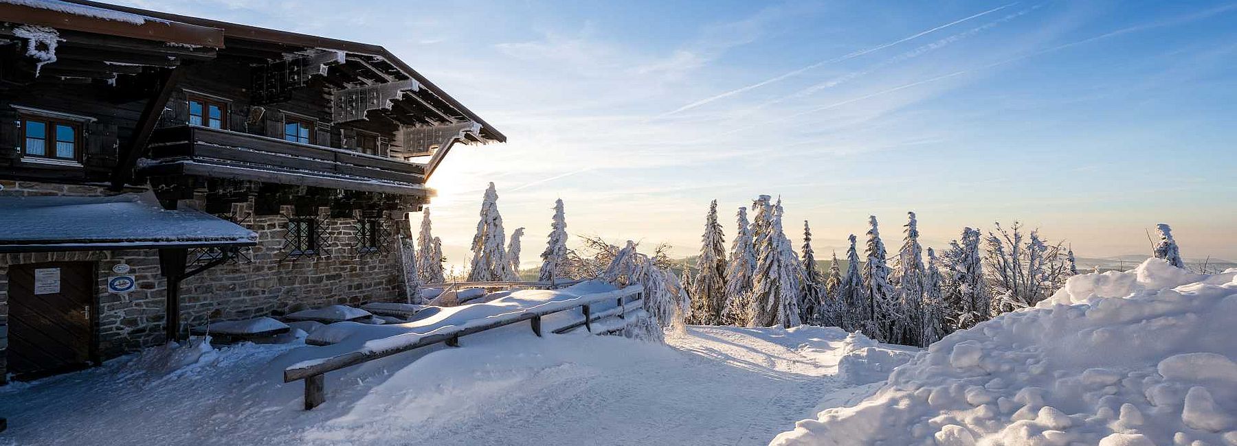 Traditionelles Gasthaus mit Balkon und verschneiter Terrasse im Bayerischen Wald