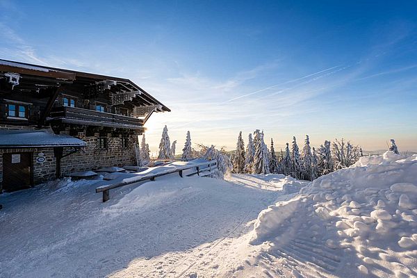 Traditionelles Gasthaus mit Balkon und verschneiter Terrasse im Bayerischen Wald